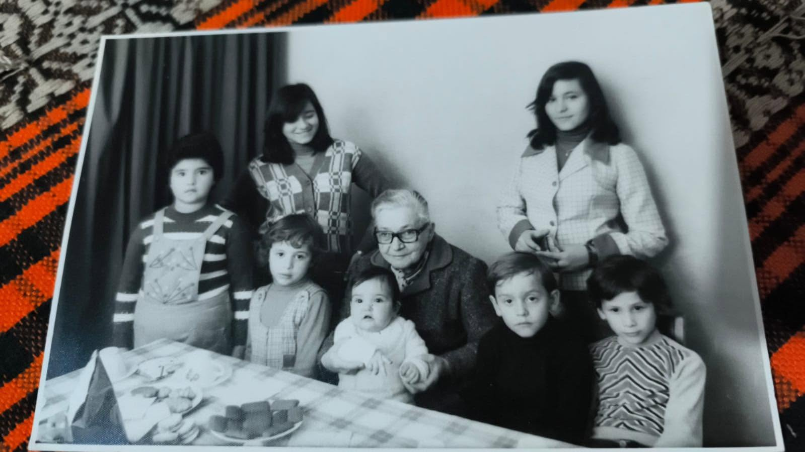 María Cosa reunida alrededor de una mesa con sus nietos y bisnietos