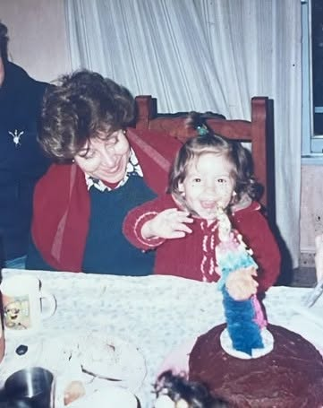 Fotografía familiar compartida por Carolina Gear: una mujer y una niña junto a una torta de cumpleaños