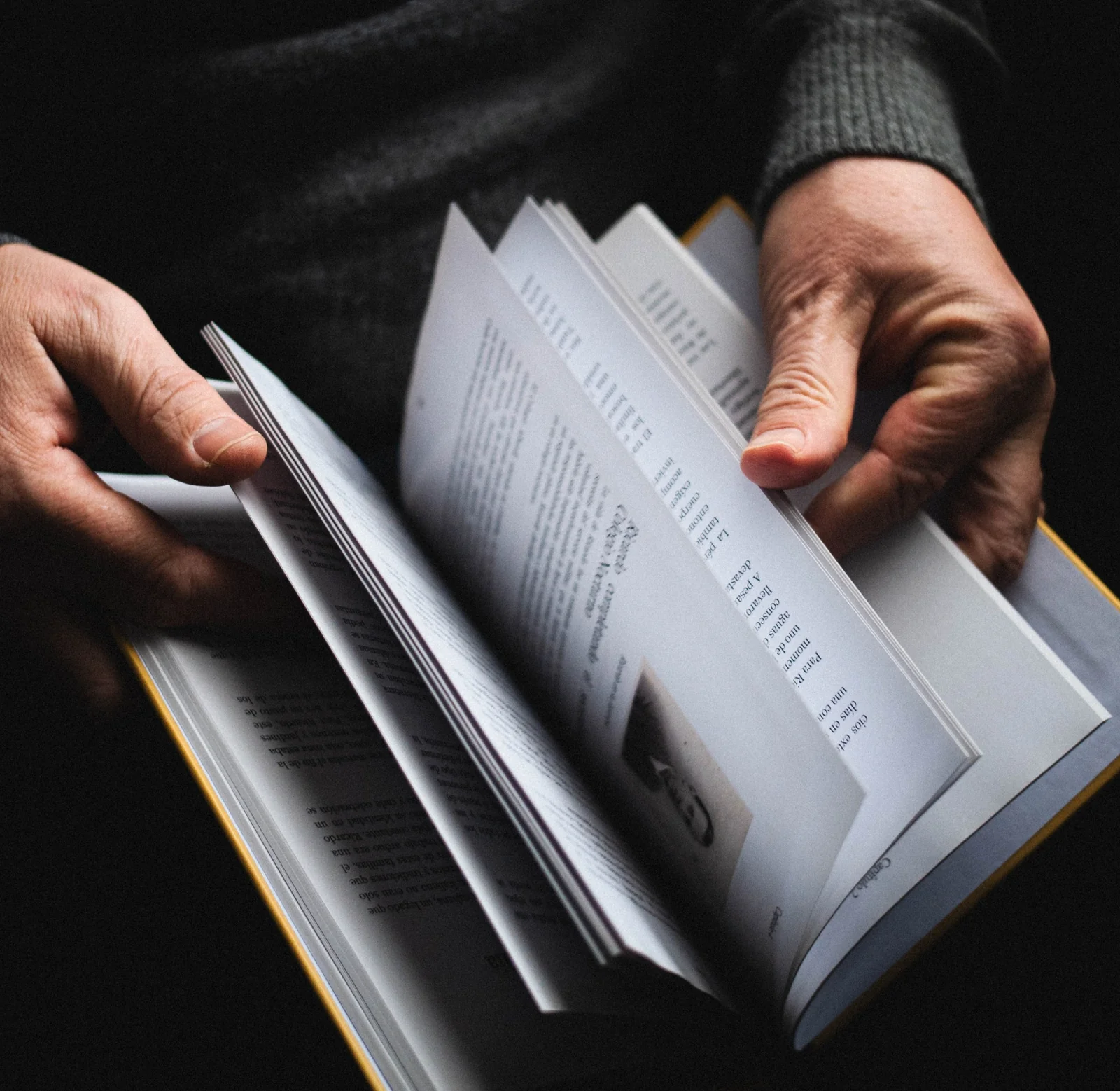 Manos hojeando un libro abierto